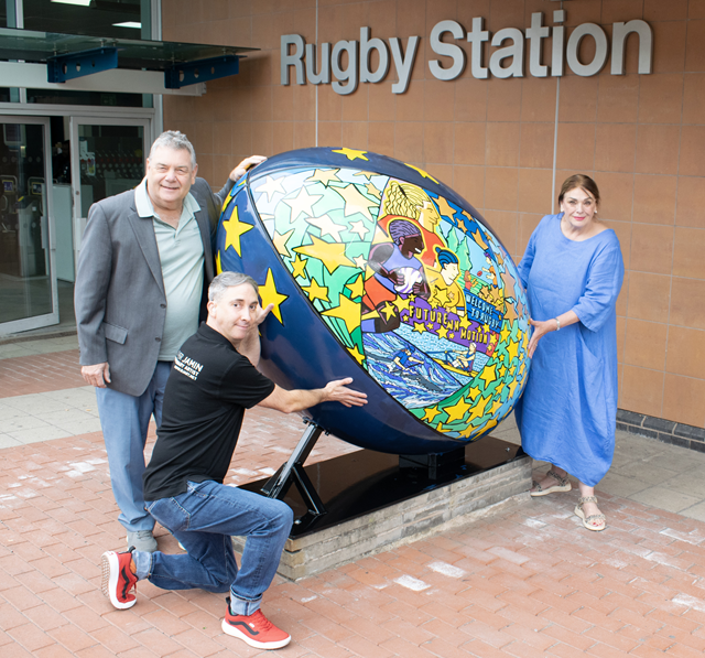 (left to right) Cllr Neil Sandison, Rugby Borough Council's Liberal Democrat group spokesperson for partnerships and wellbeing, artist Olivier Jamin and Cllr Maggie O'Rourke, Rugby Borough Council portfolio holder for partnerships and wellbeing, with the new rugby ball sculpture at Rugby railway station.