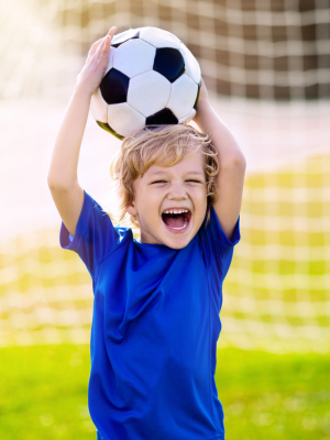 child laughing with a football